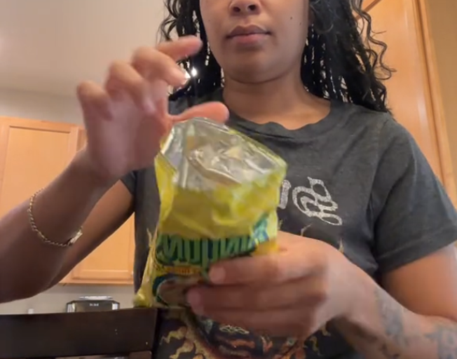 Woman holding an open back of Funyuns