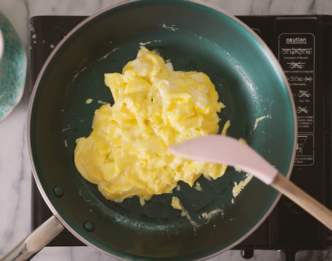 scrambled eggs cooking in a skillet