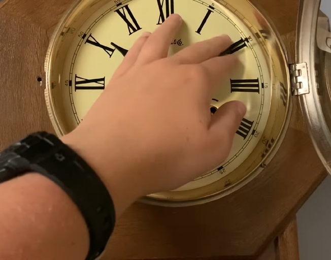 A person setting an analog clock