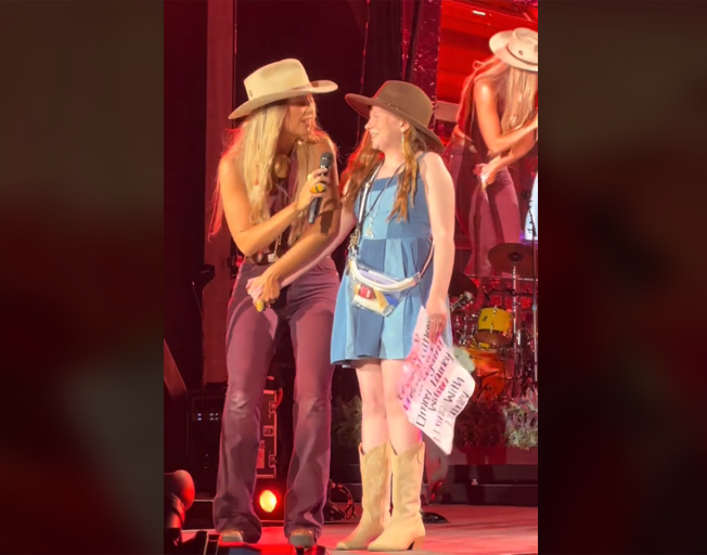 Lainey Wilson and a young fan on stage at the Walmart Amphitheater in Rogers, Arkansas 8-10-24